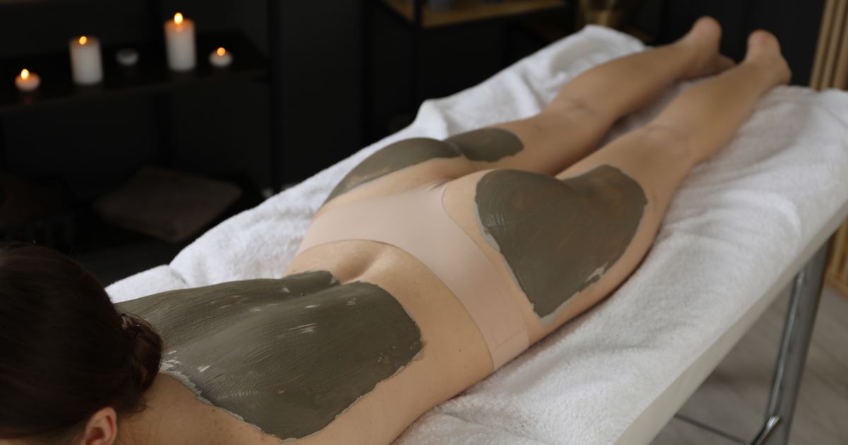 Warme Naturmoorpackung liegt auf dem Rücken einer Patientin während einer Wärmetherapie
